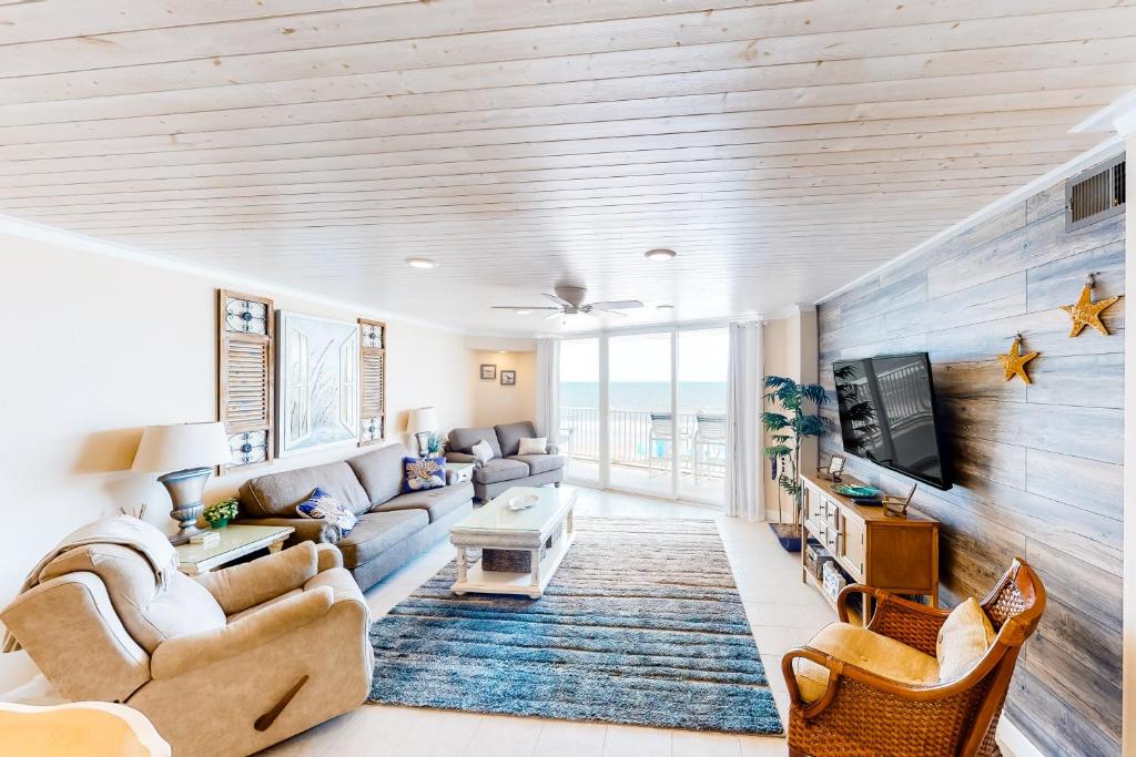uma sala de estar com um sofá e uma televisão em The Oceans Edge em North Topsail Beach