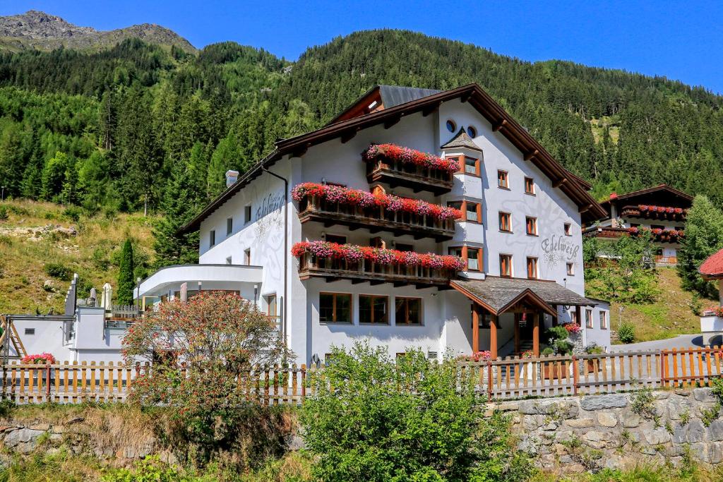 a large white building with red flowers on it at Hotel Edelweiss Superior in Kaunertal