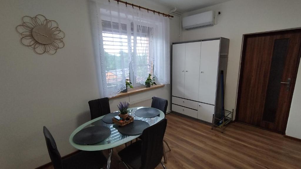 a dining room with a table and chairs and a large window at Apartmán AMSEL in Ostrov