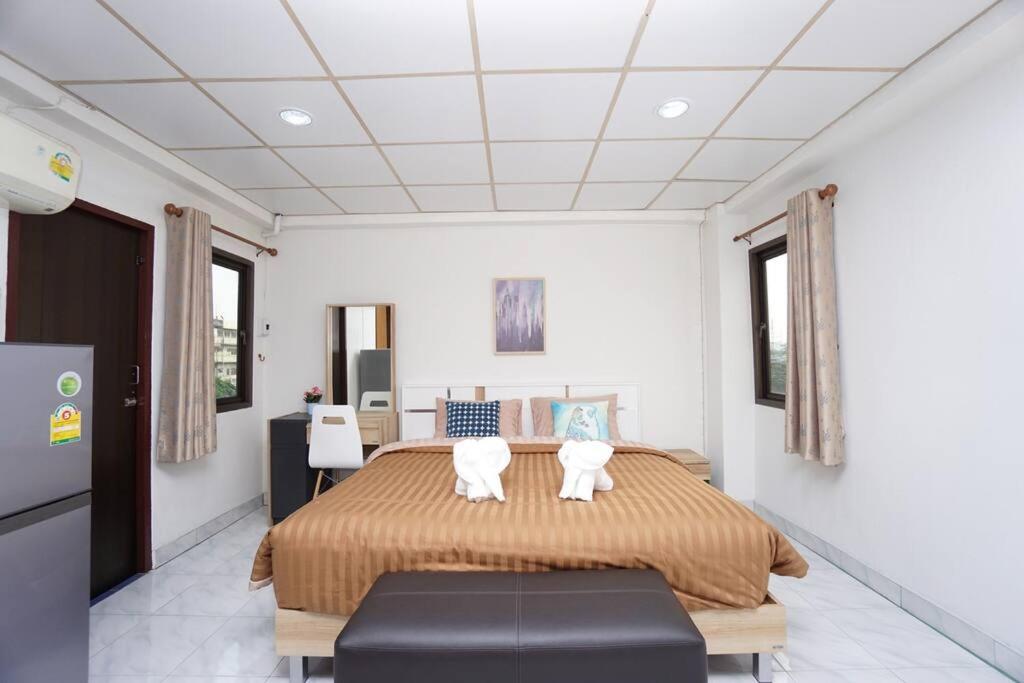 a bedroom with a large bed with two white chairs at Maruay Living Apartment 506 (Khaosan/Chinatown/Samyot MRT) in Bangkok