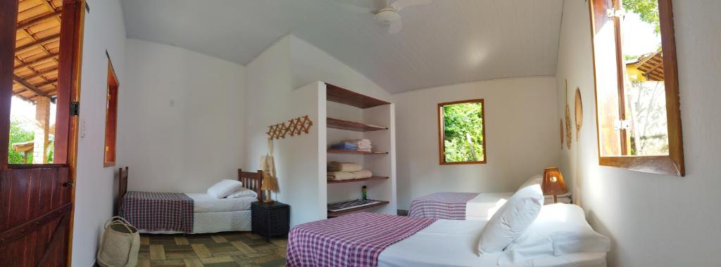 a bedroom with a bed and a chair in a room at Pousada Luar do Sertão in Lençóis