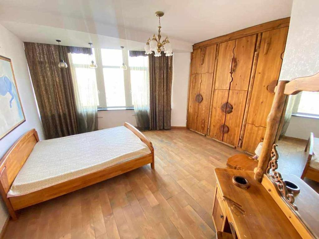 a large room with a bed and wooden cabinets at Five seasons guest house in Ulaanbaatar
