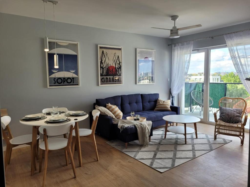 a living room with a blue couch and a table at Baltika in Gdańsk