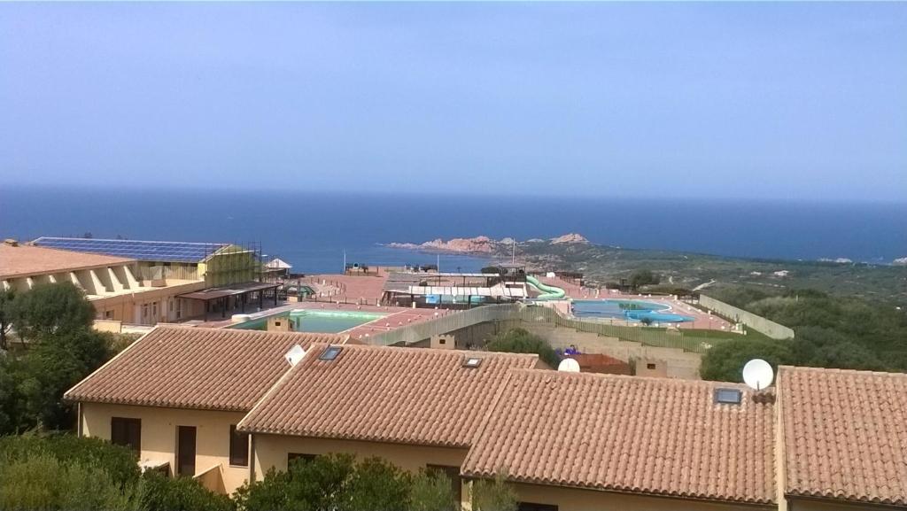 a view of a resort with a pool and the ocean at Appartamento Residence Isola Rossa in Isola Rossa