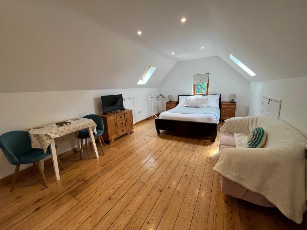 a bedroom with a bed and a desk and a tv at The Annexe at Yew Tree House in Canterbury