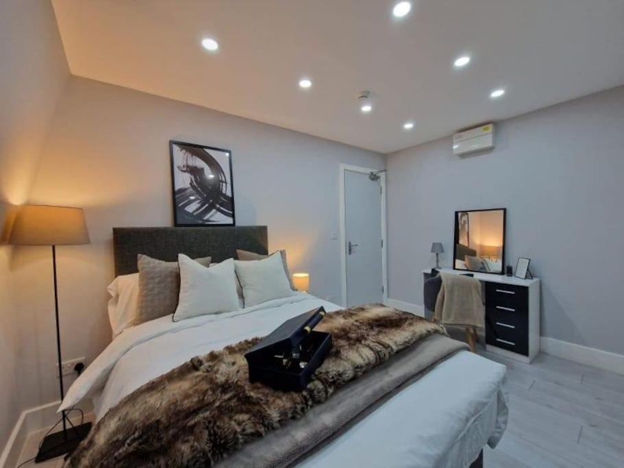 a bedroom with a large bed with a blanket on it at Hackney Spacious En-Suite in London