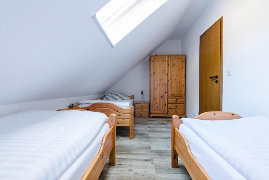 Schlafzimmer im Dachgeschoss mit 3 Betten und einem Dachfenster in der Unterkunft Landhaus Salweytal in Niedersalwey