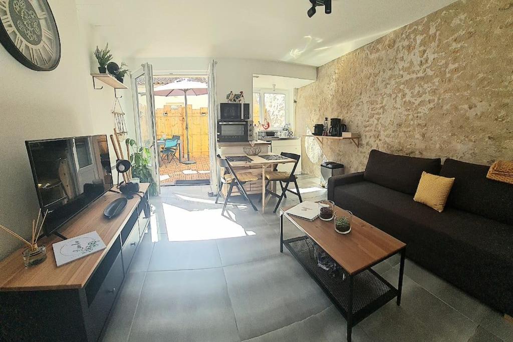 sala de estar con sofá y mesa en La Casa De Nonna - logement classé 2 étoiles en Rochefort