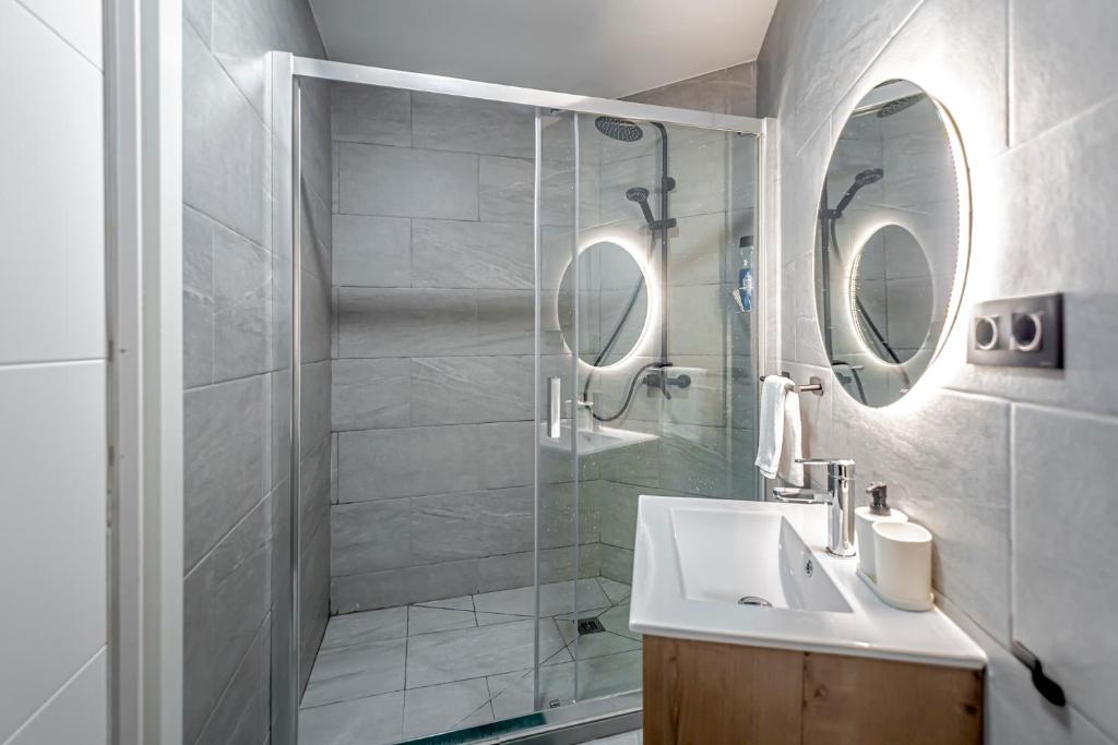 łazienka z umywalką i przeszkloną kabiną prysznicową w obiekcie Luminoso cerca 4 Caminos- Apartamento REINA VICTORIA w Madrycie