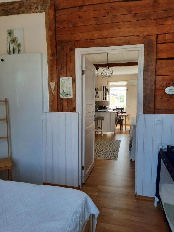 a bedroom with a white bed and a kitchen at Vintage Four in Haapsalu