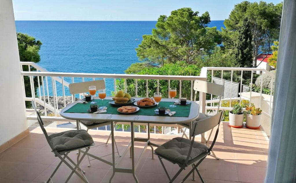 una mesa y sillas en un balcón con vistas al océano en AGUILA DORADA, en Salou