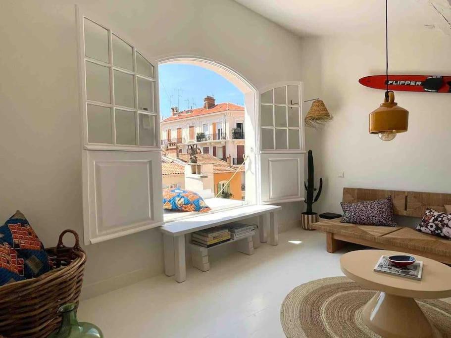 un salon avec une grande fenêtre et un canapé dans l'établissement Maison Meynadier, à Cannes