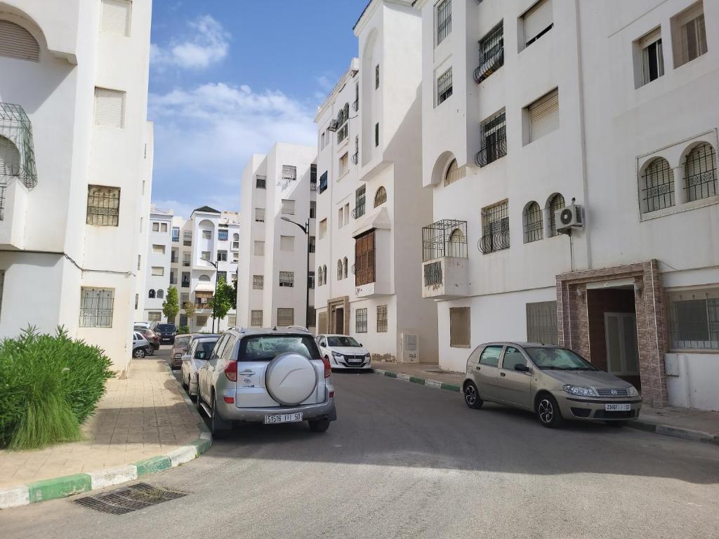 a street with cars parked in front of buildings at Complexe tamuda doha tetouan in Tetouan