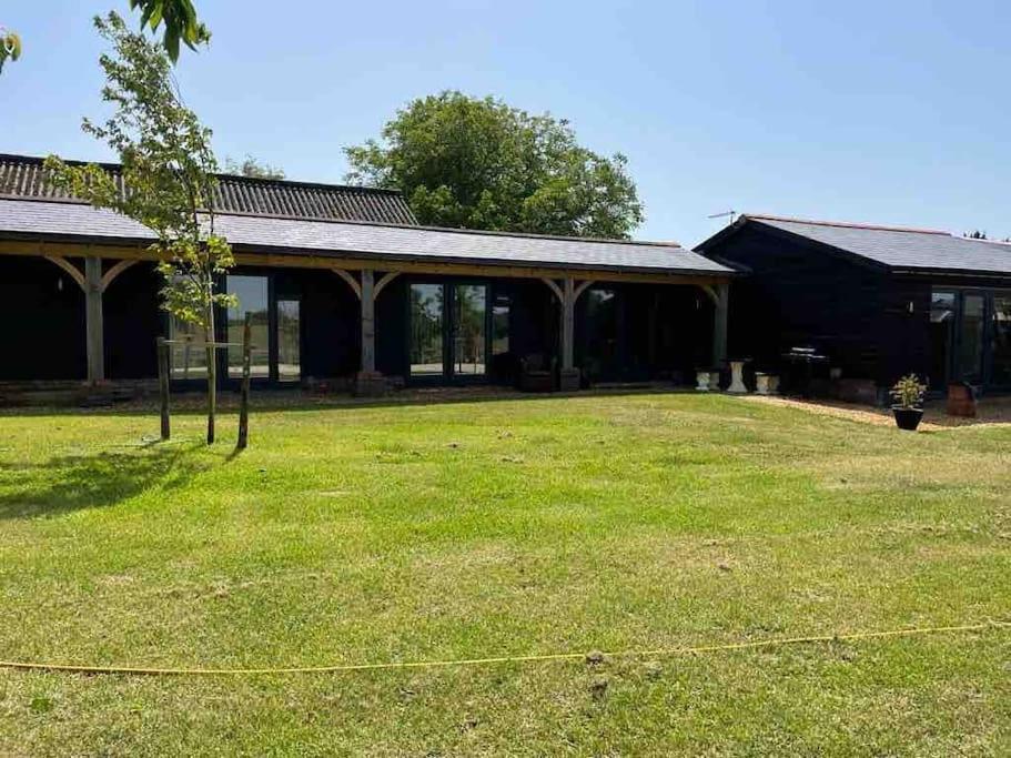 una casa con un gran patio con un edificio en The Stables, 