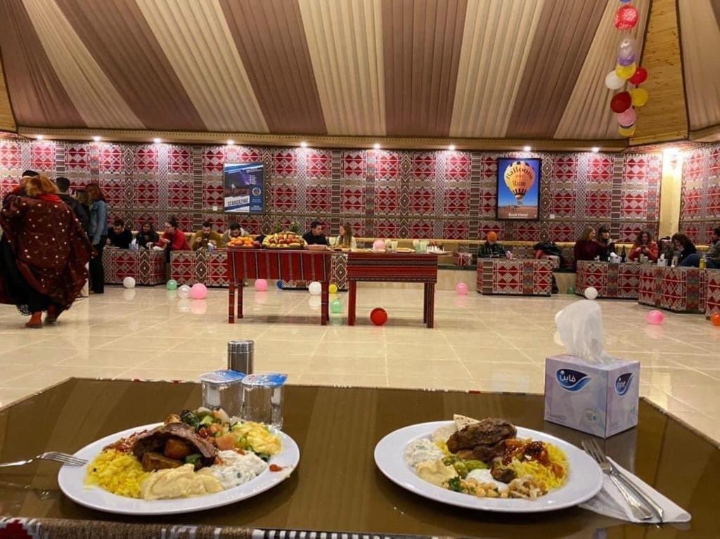 two plates of food on a table in a room at Rum city Star LUXURY Camp in Wadi Rum