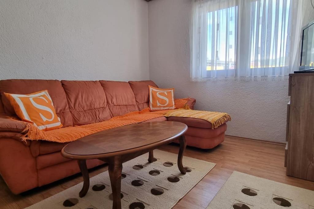 a living room with a brown couch and a table at Lana apartman in Jajce