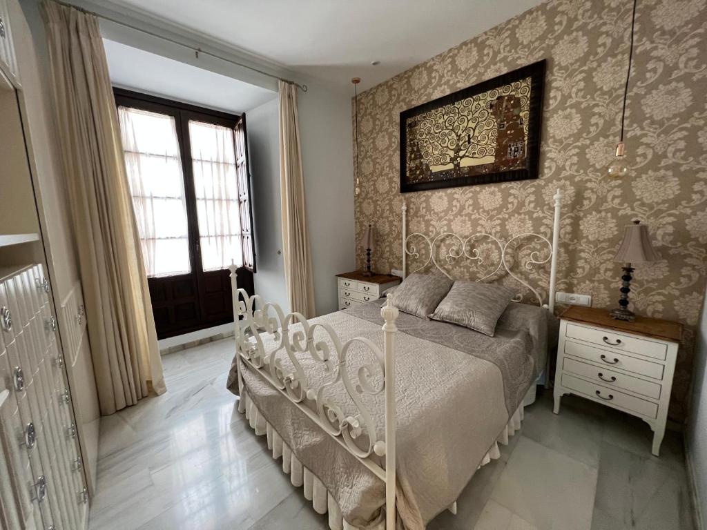 1 dormitorio con cama blanca y ventana en APARTMENT PALACIO DE LOS VIBORA, en Lucena