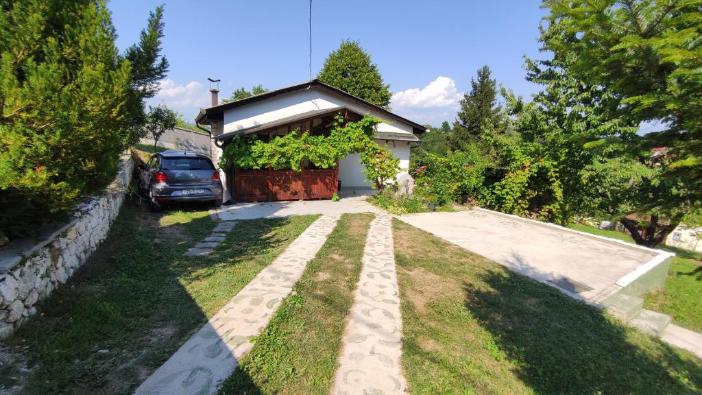 a driveway with a car parked in front of a house at Curovac Nature in Ilidža