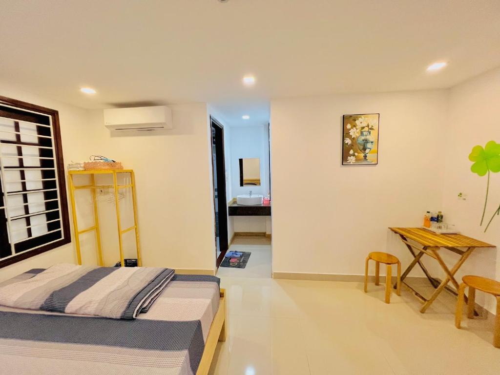 1 dormitorio con cama, mesa y escritorio en Kenppi HOMESTAY, en Hue
