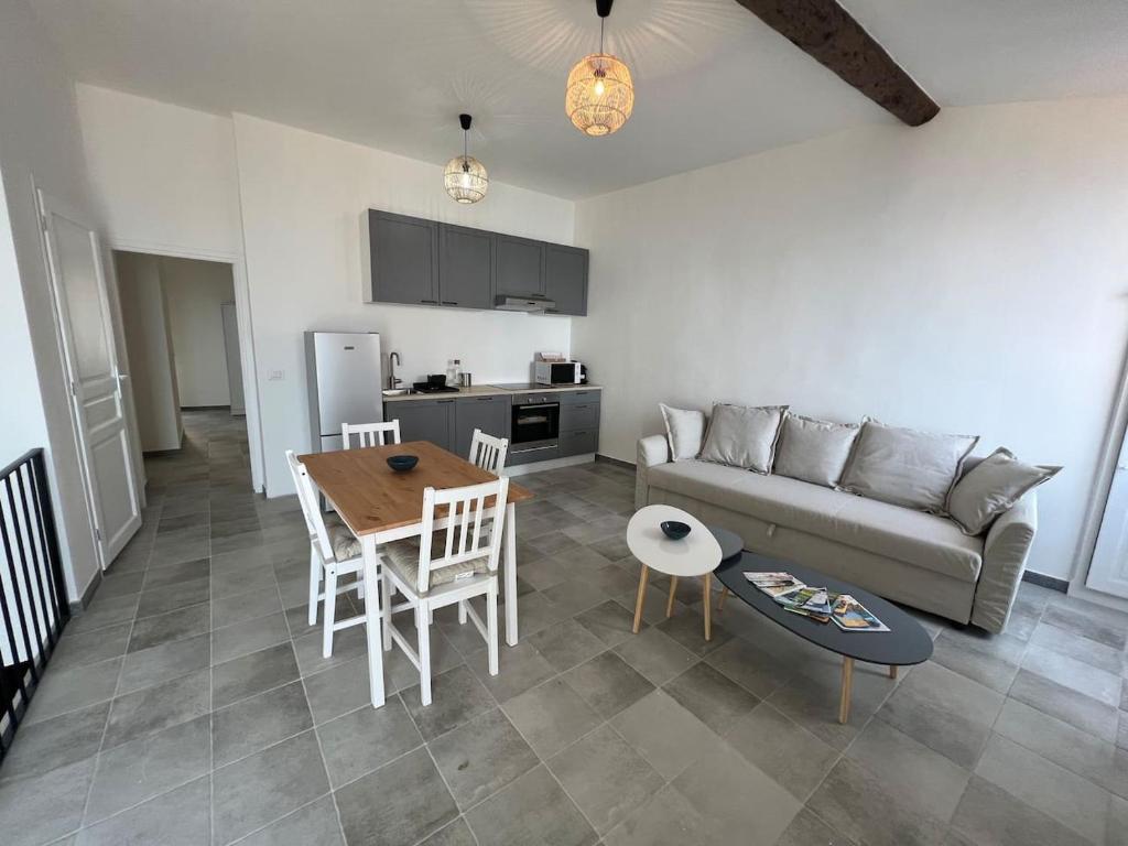 uma sala de estar com um sofá e uma mesa em Au cœur du village , vue mer em Roquebrune-Cap-Martin