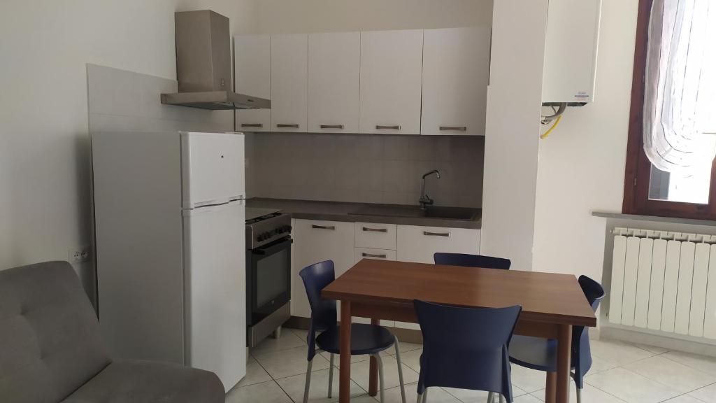 a kitchen with a wooden table and blue chairs at Accogliente appartamento Fucecchio in Fucecchio