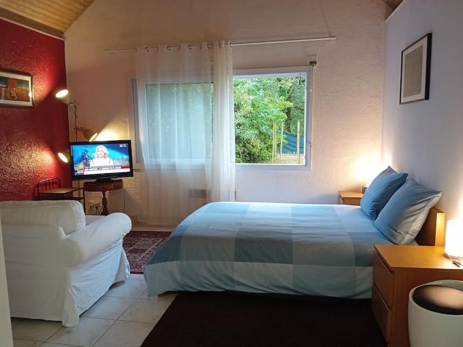 une chambre avec un grand lit et une fenêtre dans l'établissement La petite maison à la campagne / our little house, à La Chapelle-Launay