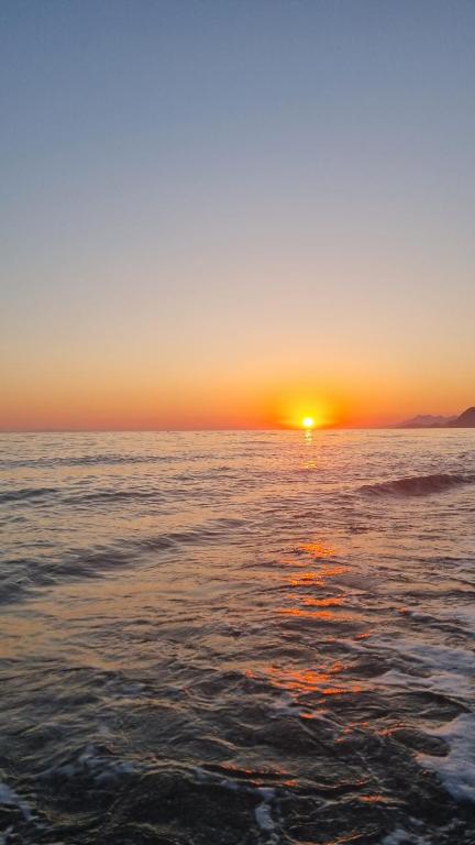 a sunset over the ocean with the sun setting at Ionian Dream Home in Vráchos