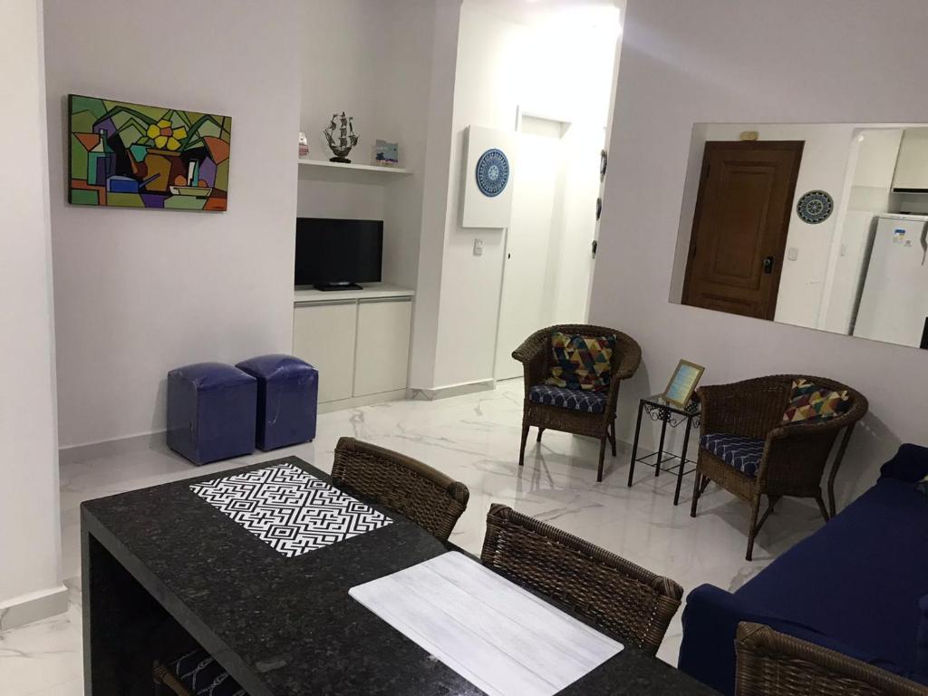 a living room with a dining room table and chairs at Capitânia Varam in Guarujá