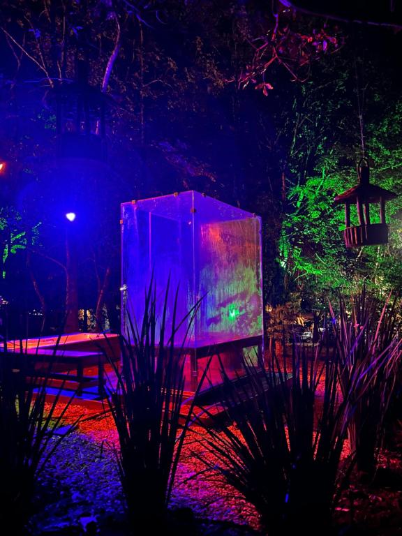 a large projection screen in a garden at night at Pousada Aconchego in Pirenópolis