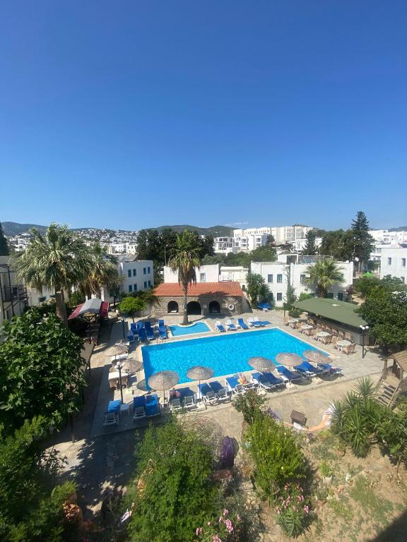 Luftaufnahme eines Pools mit Liegestühlen und Sonnenschirmen in der Unterkunft Bodrum Park Hotel in Gümbet