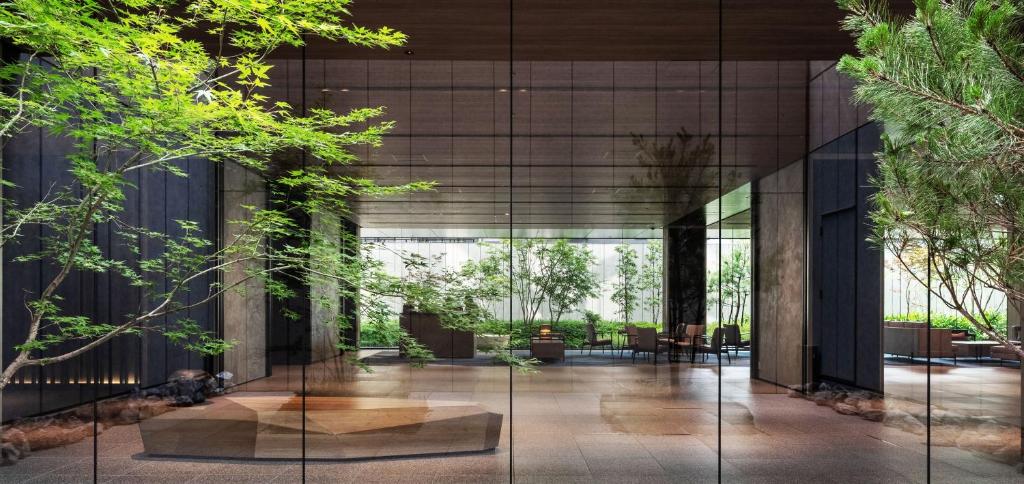 京都的住宿－Richmond Hotel Premier Kyoto Shijo，一座拥有玻璃墙和树木的建筑的大堂