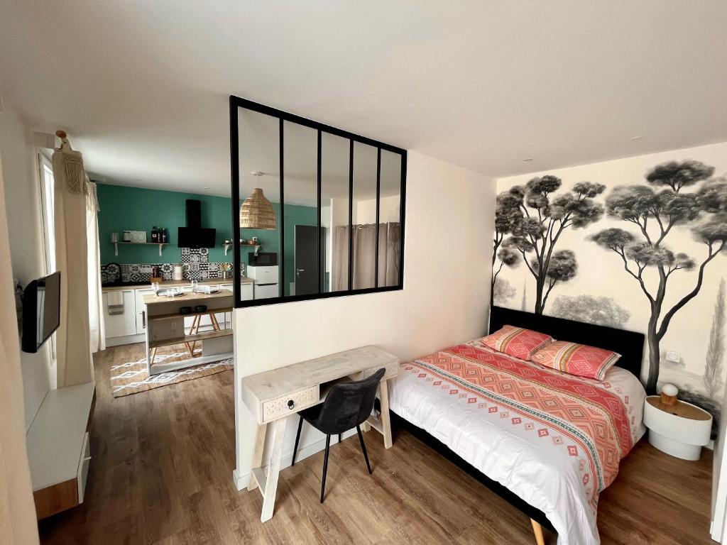 a bedroom with a bed and a desk and a kitchen at STUDIO IBIZA - HYPER CENTRE LORIENT in Lorient