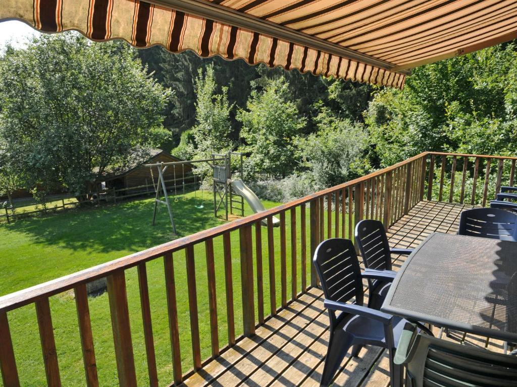 una terraza con sillas y mesa y vistas a un patio en Cosy Holiday Home in Noiseux with Large Garden, en Noiseux