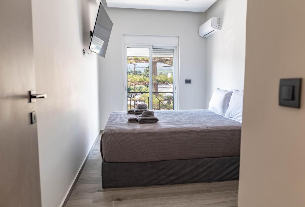 a small bedroom with a bed and a window at oiKOS Hospitality in Kos