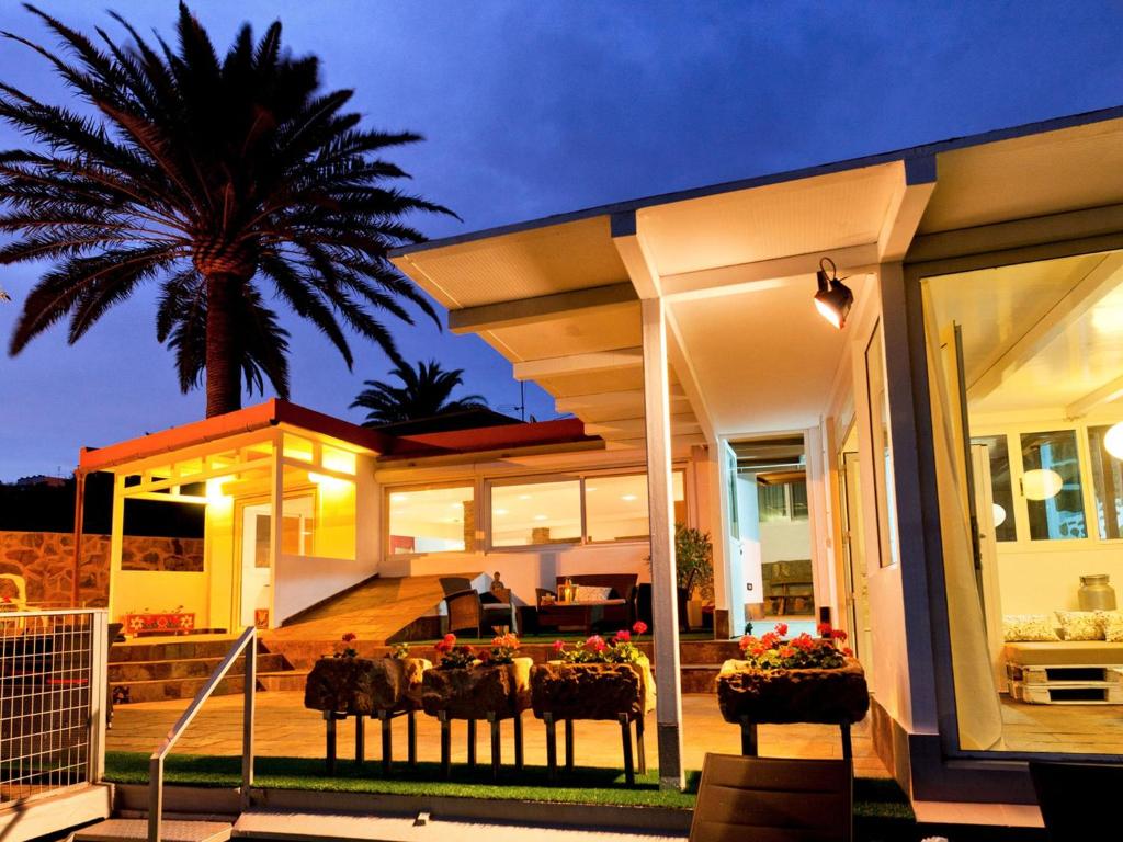 een huis met een palmboom ervoor bij Magnificent Villa with Swimming Pool on an Exclusive Island in Ingenio