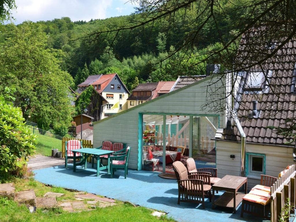 een patio met een tafel en stoelen en een huis bij Quiet and cosy holiday home in Herzberg in Herzberg am Harz