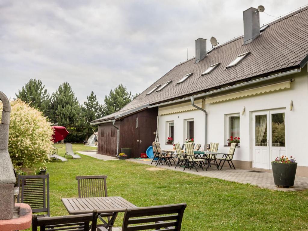 een huis met een tafel en stoelen in de tuin bij Spacious Villa in Nemojov Bohemian with Swimming Pool in Nemojov