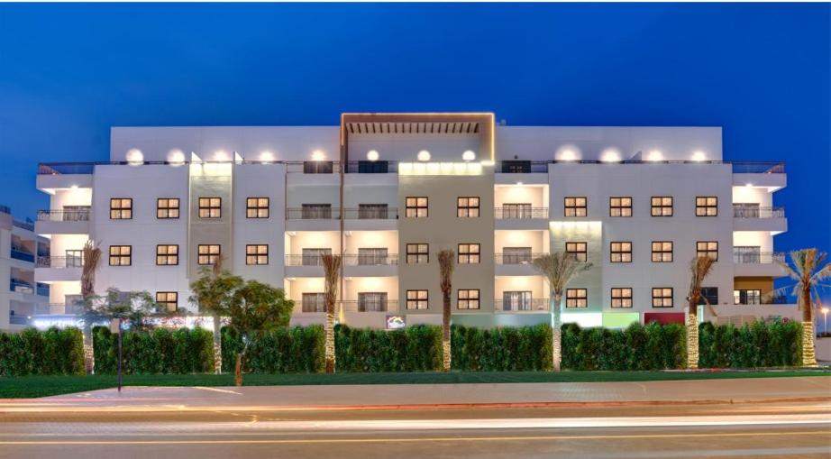 a large white building with trees in front of it at City Stay Residences - Serviced Apartments DIP in Dubai