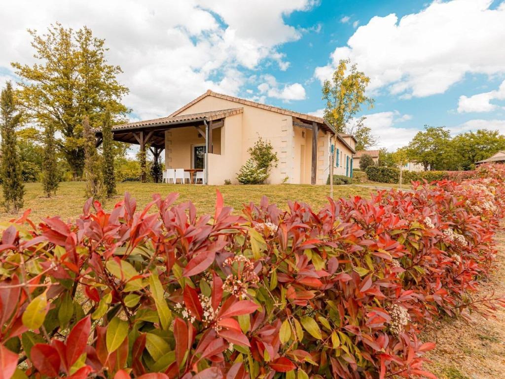 ein Haus mit roten Pflanzen davor in der Unterkunft Spacious and modern villa with large garden and BBQ area in Les Forges