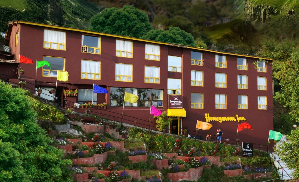 un edificio con un montón de flores delante de él en Honeymoon Inn Mussoorie, en Mussoorie