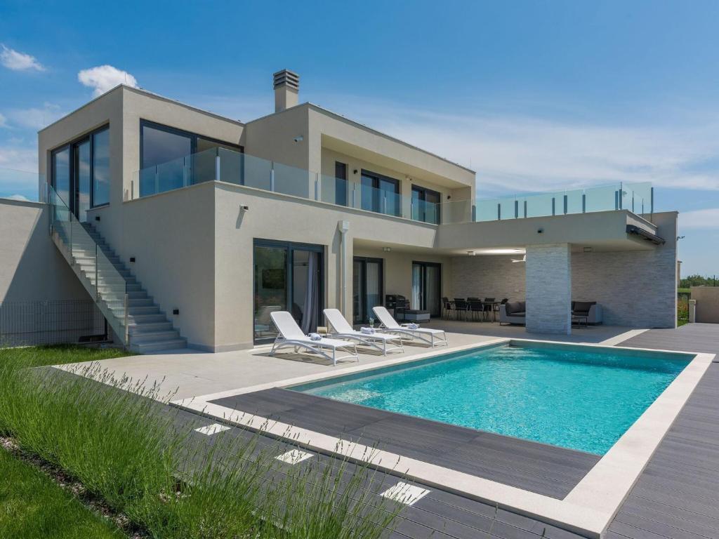 a villa with a swimming pool in front of a house at Apartment in Croatia near the Coast in Brtonigla
