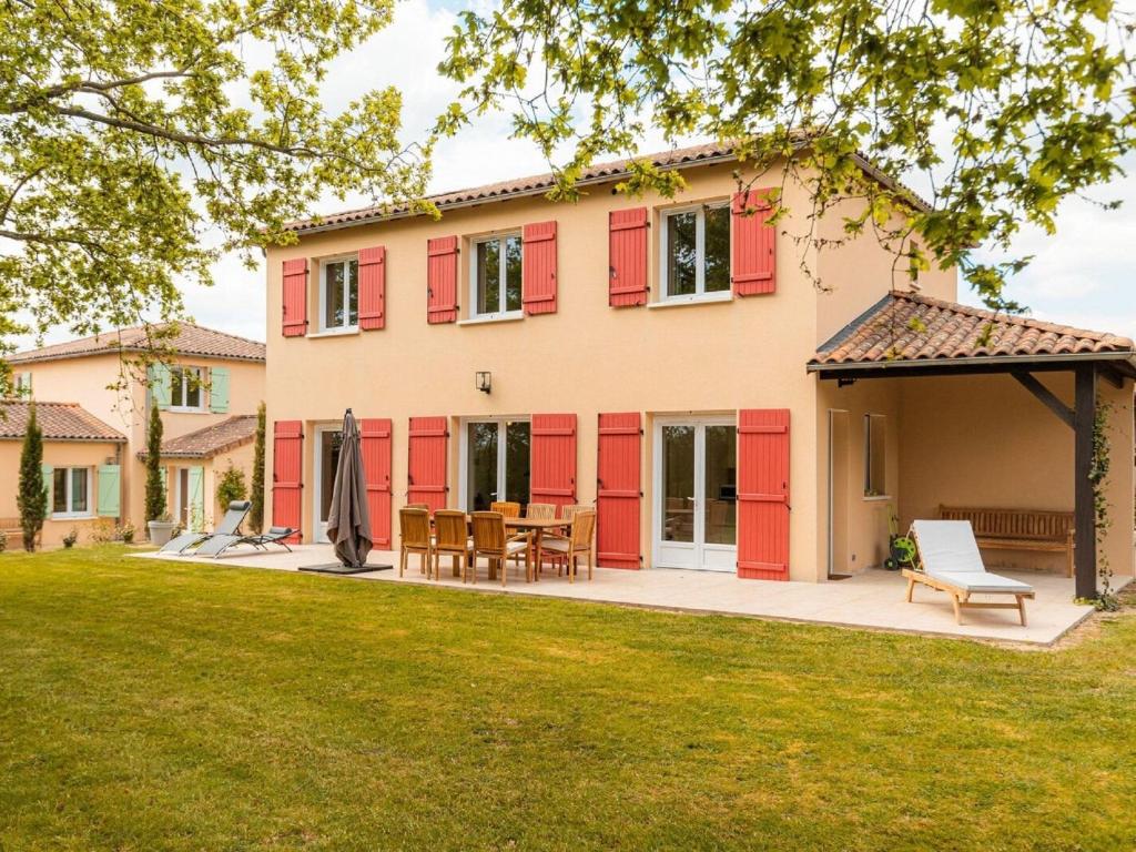 una casa con puertas rojas y un patio en Spacious and modern villa with large garden and BBQ area en Les Forges