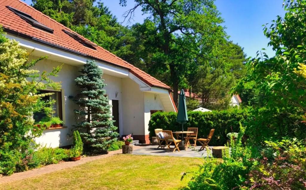 a patio with a table and chairs in a garden at Apartamenty Winniczki in Pobierowo