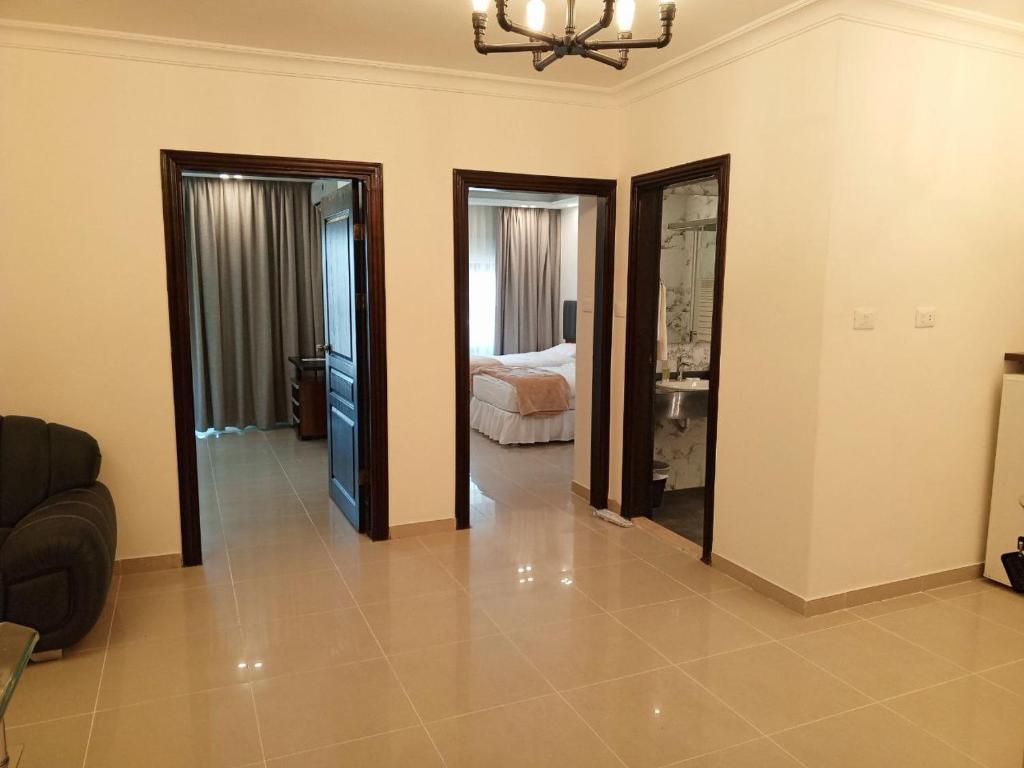 een woonkamer met 2 deuren en een slaapkamer bij Sedrah Hotel in Irbid