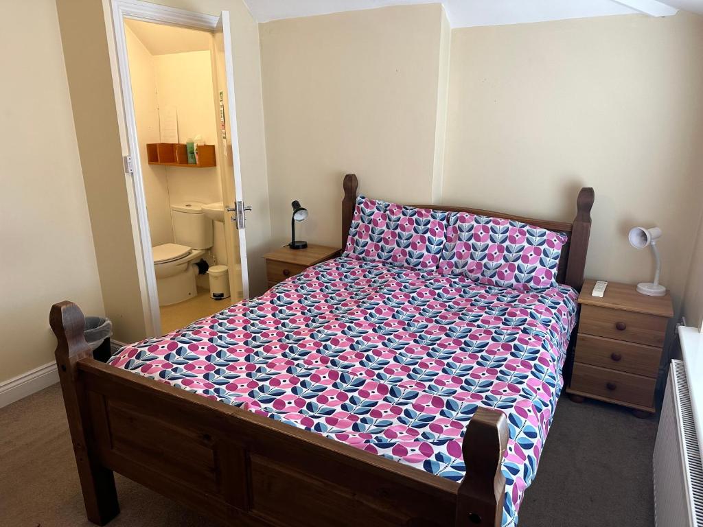 - une chambre avec un lit doté d'une couverture fleurie dans l'établissement 287 Green Lanes, à Londres