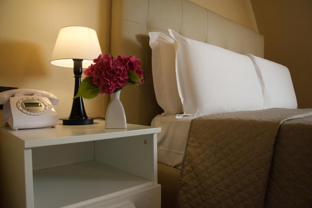 a hotel room with a bed and a table with a phone at Hotel Valentino Du Parc in Turin