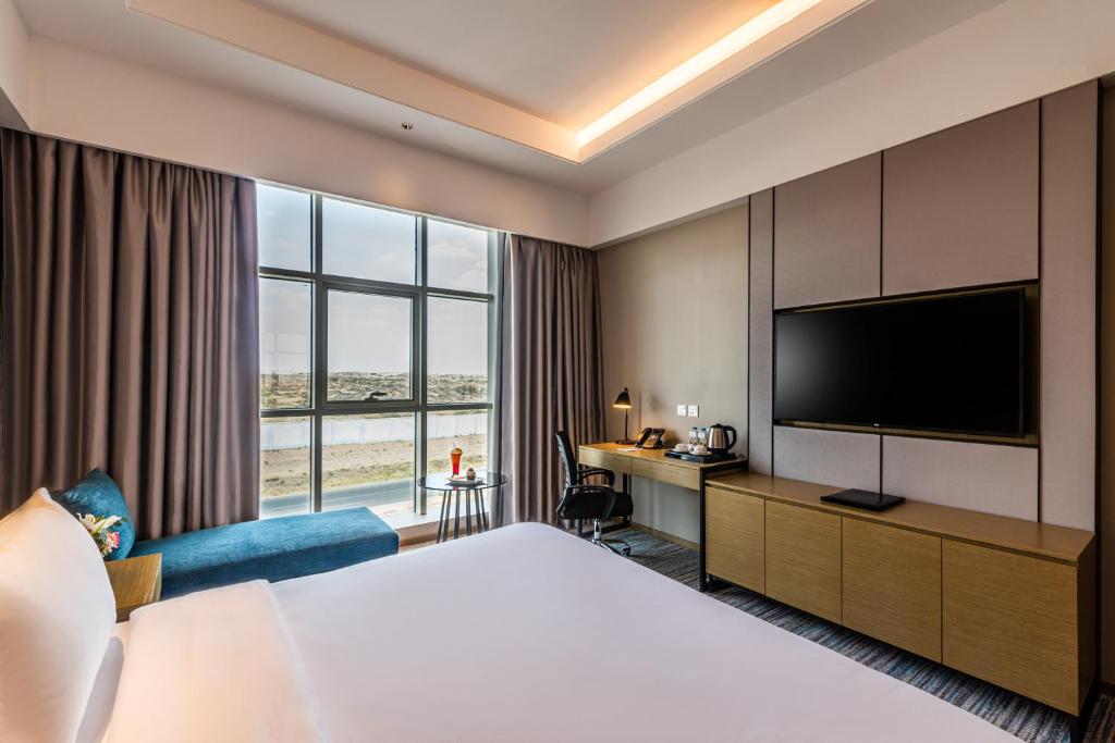 a hotel room with a bed and a flat screen tv at Boudl Khamis Mushait in Khamis Mushayt