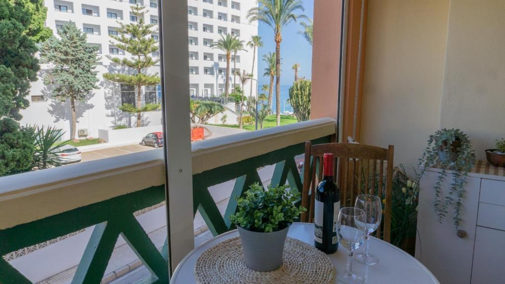 einen Tisch mit Weingläsern und eine Pflanze auf dem Balkon in der Unterkunft Apartamento_Nerja in Nerja