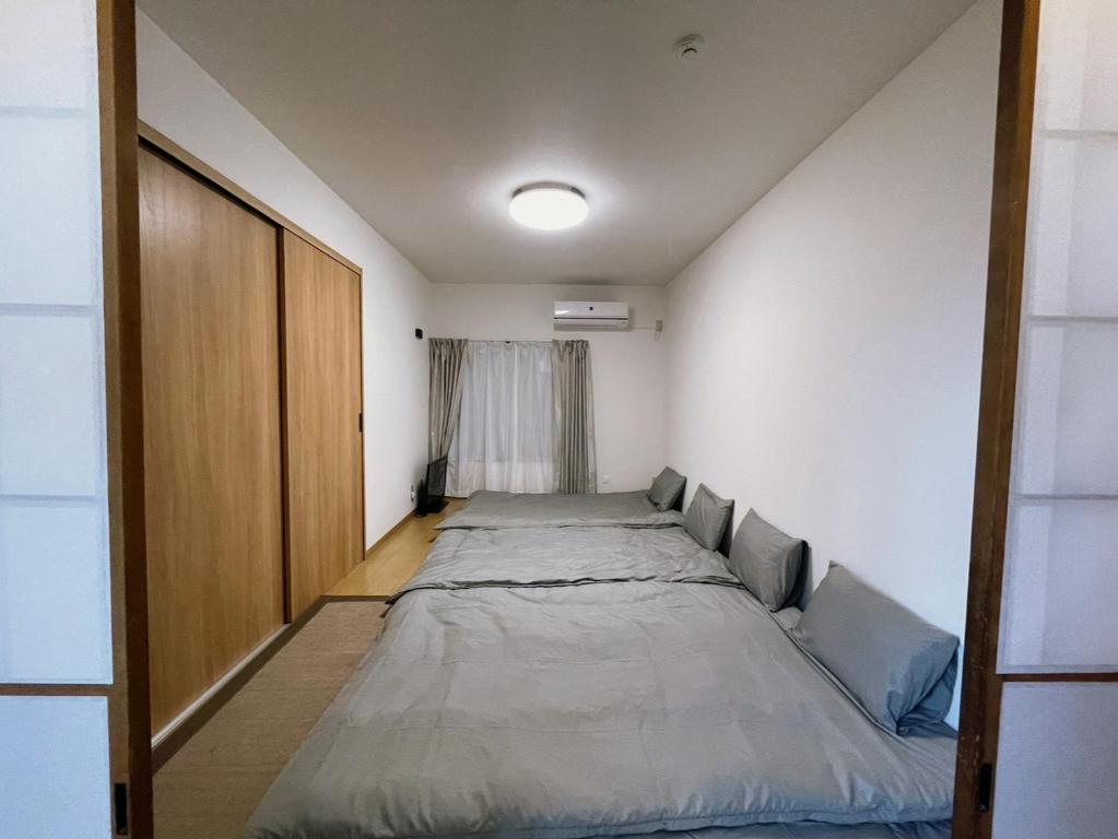 Postel nebo postele na pokoji v ubytování 青梅森の宿