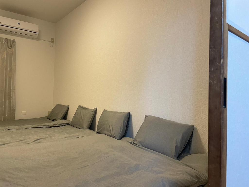 Postel nebo postele na pokoji v ubytování 青梅森の宿